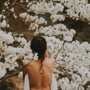 topless person standing near white petaled flowers